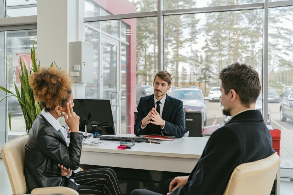 Un datore di lavoro discute con due dipendenti in un ufficio moderno, evidenziando l'importanza dell'attenzione all'ambiente per promuovere il comportamento caritatevole dei dipendenti.